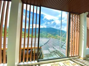 Elle comprend une grande fenêtre offrant une vue sur la montagne. dans l'établissement Ánh Sao Sapa Hotel, à Sa Pa