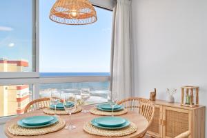 a dining room with a table with chairs and a window at Kanu Apartment - Torrox Costa in Torrox Costa