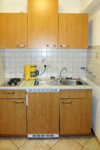 uma cozinha com armários de madeira e um lavatório em Apartment Landhaus Heim - ZAZ305 by Interhome em Zell am Ziller