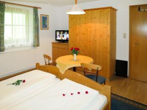 um quarto com duas camas e uma mesa e uma televisão em Apartment Landhaus Heim - ZAZ305 by Interhome em Zell am Ziller