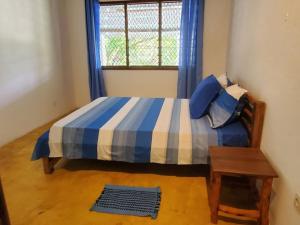 1 dormitorio con 1 cama, ventana y mesa en Charmante villa familiale proche de la mer, en Mahajanga
