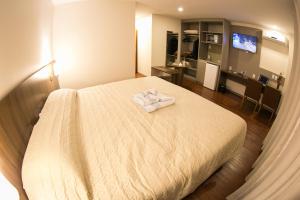 ein Hotelzimmer mit einem Bett mit zwei Handtüchern darauf in der Unterkunft Hotel Dom Rafael Premium in Santa Maria