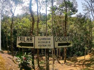 dwa znaki na szlaku w lesie w obiekcie Pousada Caminhos de Gaia w mieście São José dos Campos