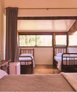 sypialnia z 2 łóżkami i oknem w obiekcie Pousada Caminhos de Gaia w mieście São José dos Campos