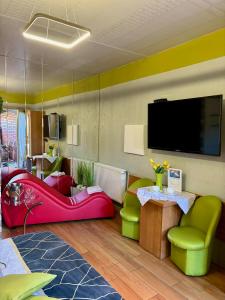 a living room with colorful furniture and a flat screen tv at Apartament "Love Island" z Jacuzzi SPA dla Dwojga in Gniezno