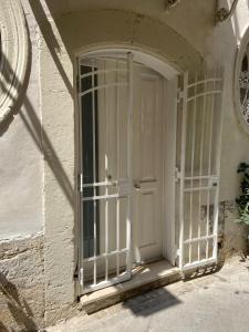 a white door with bars on the side of a building at Casa Angelino in Siracusa