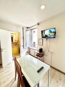 a living room with a white table and a tv on the wall at MODERNO APPARTAMENTO IN Piazza SAN GIACOMO in Udine