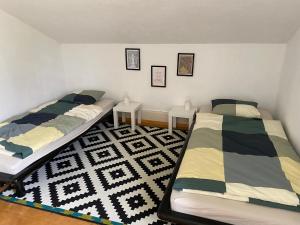 a bedroom with two beds and a rug at Appart' dans maison villageoise in Boudry