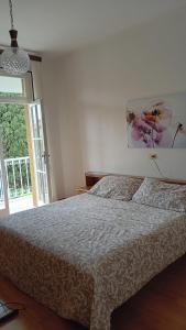 - une chambre avec un lit et une grande fenêtre dans l'établissement villetta le palme, à Toscolano Maderno