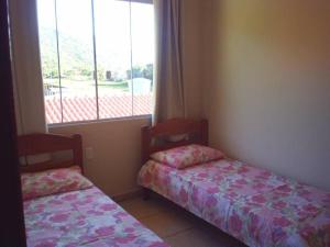 2 camas en una habitación con ventana en Pousada Porto dos Mares, en Pinheira