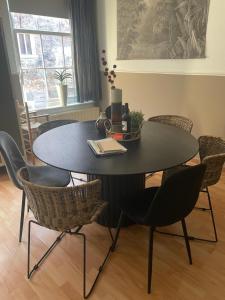uma mesa de jantar preta com cadeiras à volta em Casa Elburg em Elburg