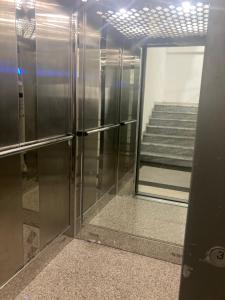 un ascensor en un edificio con una puerta de cristal en Azure beach apartment, en Orikum