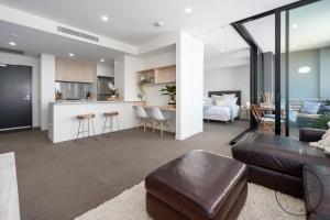 uma sala de estar com um sofá e uma cozinha em Beachfront Beauty - Wifi Included em Newcastle