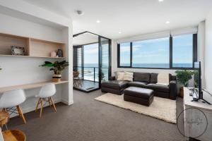 uma sala de estar com um sofá e uma mesa em Beachfront Beauty - Wifi Included em Newcastle