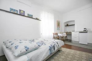 ein weißes Schlafzimmer mit einem Bett und einer Küche in der Unterkunft Nick's Old Town Apartment in Labin