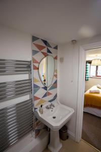 ein Bad mit einem Waschbecken und einem Spiegel in der Unterkunft West Hollowcombe Farm in Dulverton