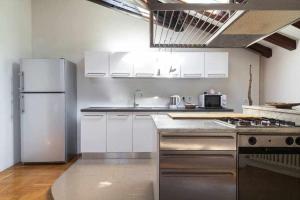 メストレにあるAttic floor venice apartmentのキッチン(白いキャビネット、ステンレス製の冷蔵庫付)