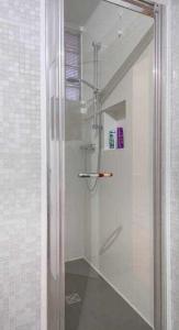 La salle de bains est pourvue d'une douche avec une porte en verre. dans l'établissement Attic floor venice apartment, à Mestre