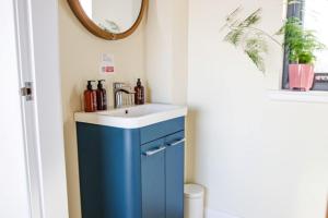 a bathroom with a blue cabinet and a sink at The Boathouse in Tomich