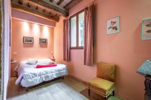 ein Schlafzimmer mit einem Bett, einem Stuhl und einem Fenster in der Unterkunft La Torre di Monsindoli in Siena