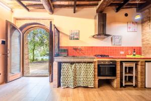 eine offene Küche mit einer Theke und einer offenen Tür in der Unterkunft La Torre di Monsindoli in Siena
