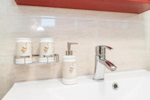 a bathroom sink with two cups and a faucet at Ema's Olive Garden Apt 1 with private parking, just 10 minutes drive from sandy beach in Poličnik