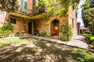 an exterior view of a brick house with a yard at La Torre di Monsindoli in Siena