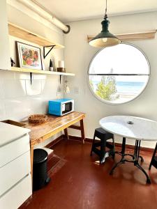 eine kleine Küche mit einem Tisch und einem Fenster in der Unterkunft Boulevard 10 - Dúplex frente al mar con balcón y vista panorámica in Puerto Madryn