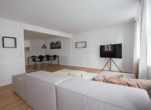 uma sala de estar com um sofá branco e uma televisão em Beautiful 2-bed in top Copenhagen location em Copenhague