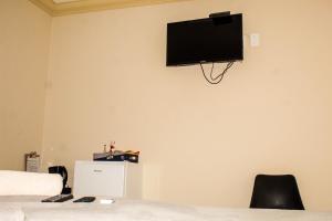a bedroom with a tv on the wall at Ingwenya Guesthouse in Ermelo