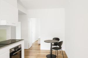 a kitchen with two black chairs and a table at Fantastic 2-bed apartment with balcony in Odense