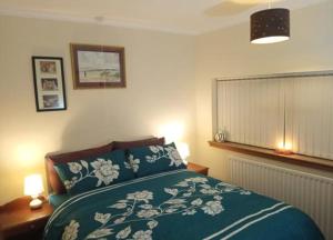 una camera con un letto con una coperta blu e bianca di Inviting 3-Bed Apartment in Walsall a Walsall