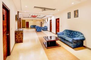 uma sala de estar com sofás azuis e uma mesa em Townhouse Prince Chowk Near Railway Station em Dehradun