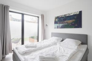 a white bed in a room with a large window at Fantastic 1-bed apartment w private terrace in Aarhus