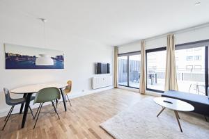 een woonkamer met een tafel en een blauwe bank bij Cool 1-bed with private terrace in Kopenhagen