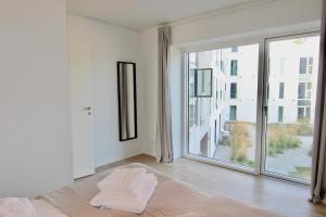 a white room with a large window and a bed at Great 2-bed wprivate balcony by Odense Harbour in Odense