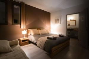 ein Schlafzimmer mit einem Bett und einem Sofa in der Unterkunft B&B Maison d'hôte et gite Mas d'Eymard in Arles