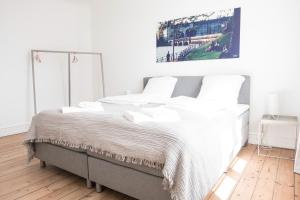 a white bedroom with a large bed with white pillows at Beautiful 2-bedroom apartment with a large balcony in Nørrebro - 65 in Copenhagen
