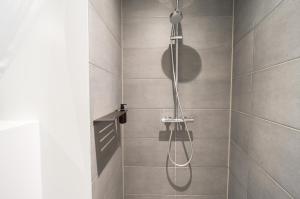 a shower with a shower head in a bathroom at Private Townhouse w terrace in Aarhus