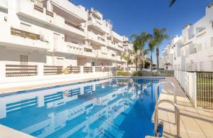 a swimming pool in front of a building at Apartamento Golf Valle Romano in Estepona