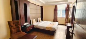 um quarto com uma cama e uma cadeira em Hotel perial Inn - Nehru Palace em Nova Deli