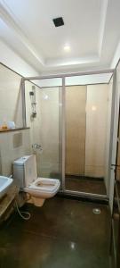 y baño con ducha, aseo y lavamanos. en Hotel perial Inn - Nehru Palace en Nueva Delhi