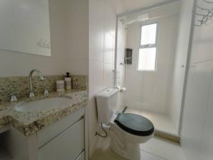 a bathroom with a toilet and a sink and a shower at Apto Centro Catedral RC1102 in Maringá