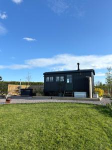 a black house with a lawn in front of it at The Winford Retreat in Winford