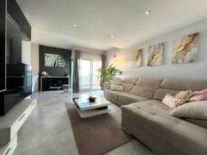 een woonkamer met een bank en een tafel bij Apartamento Golf Valle Romano in Estepona