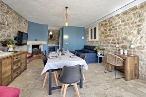 Villa Maraus by PosarelliVillas في ماراوسا: غرفة معيشة مع طاولة مع كراسي وأريكة
