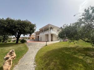 a large white house with a walkway at Villa Maccioni in Budoni