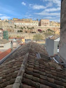 an old tile roof with a city in the background at IL GINEPRO house in Cagliari