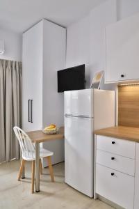 a kitchen with a white refrigerator and a table at Centro Apartments by Comfortbnb- Sitia in Sitia
