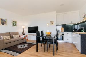 a kitchen and living room with a table and a couch at Casa Ti'Rosa in Caniço